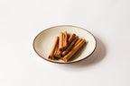 Ceylon Cinnamon sticks on a ceramic plate with a white background