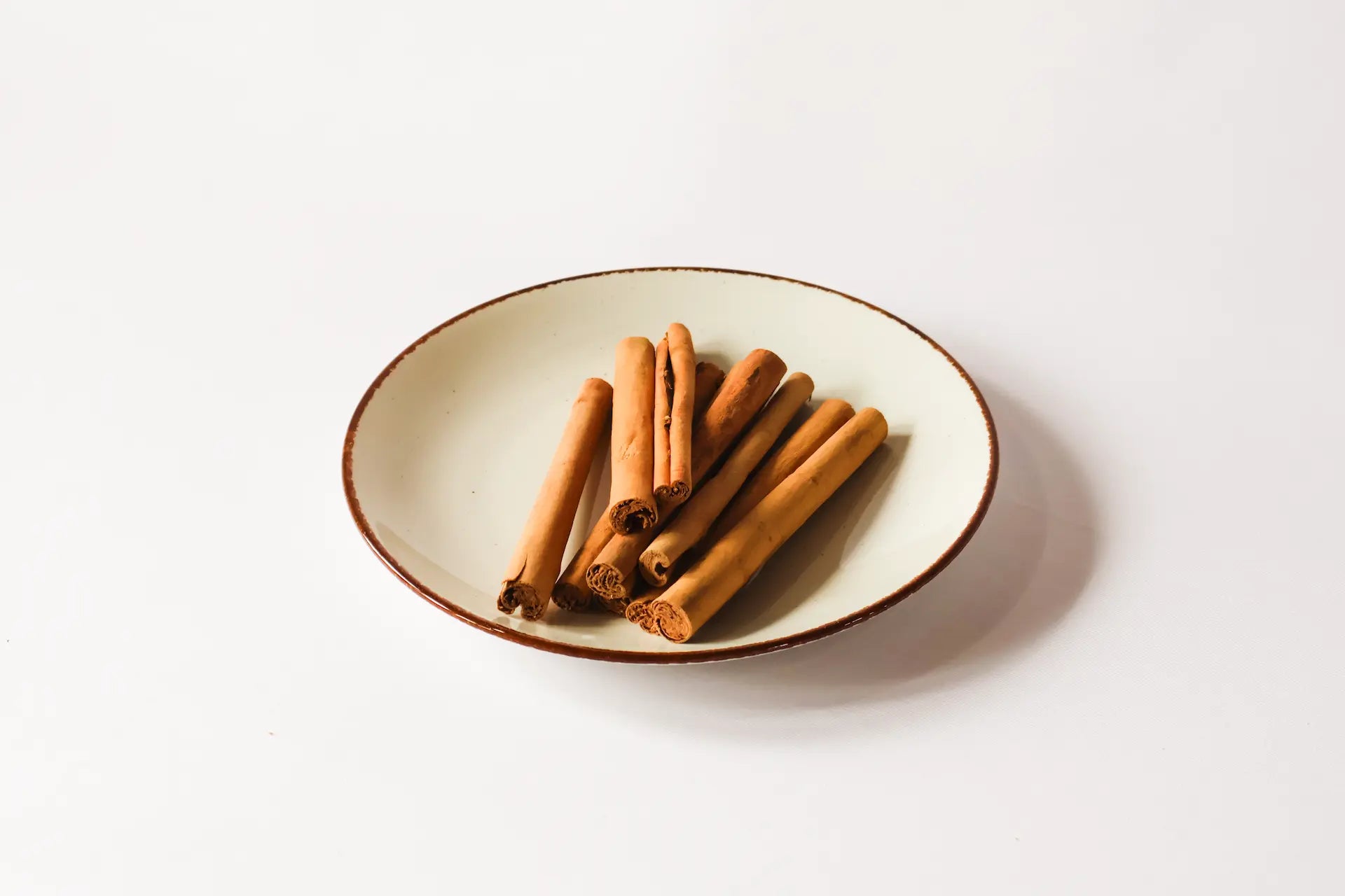 Ceylon Cinnamon sticks on a ceramic plate with a white background